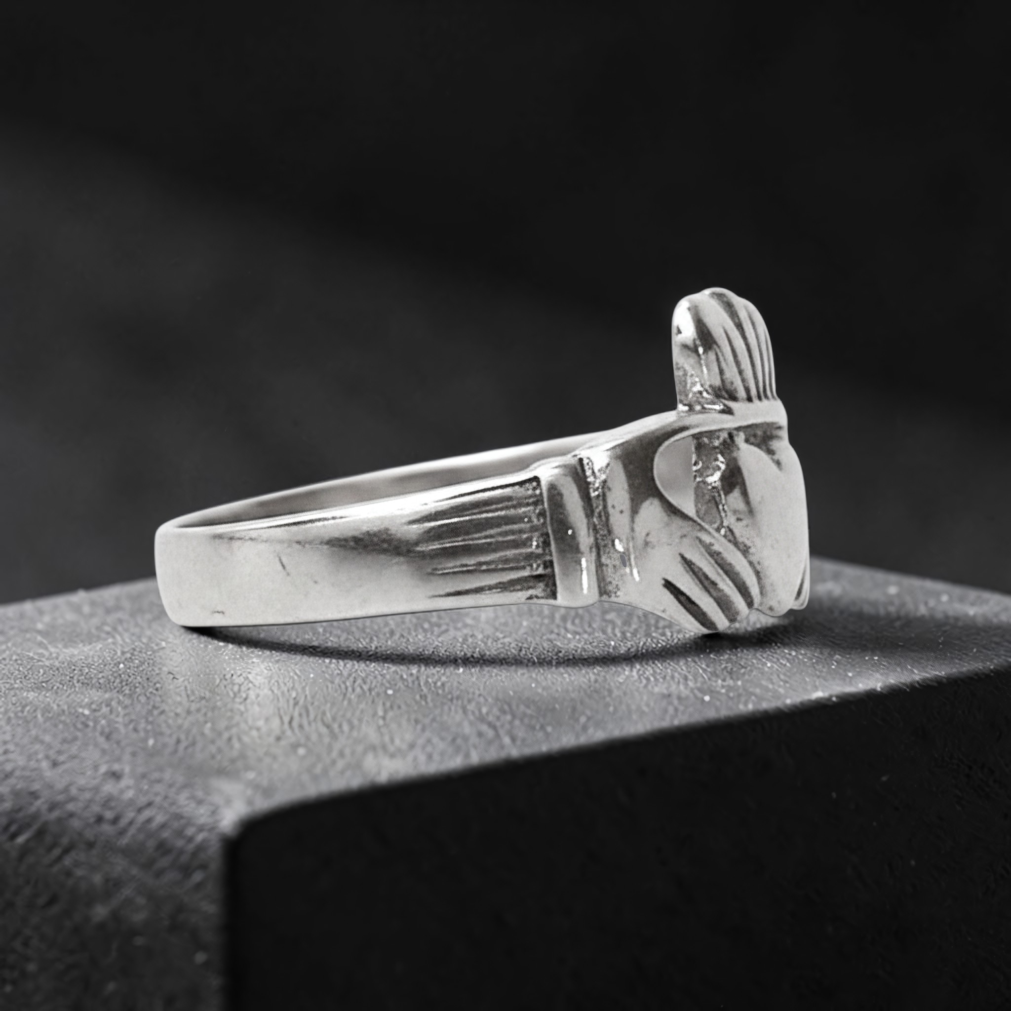 Claddagh-Ring aus Sterling Silber von der Seite, mit Händen und gerippten Manschetten