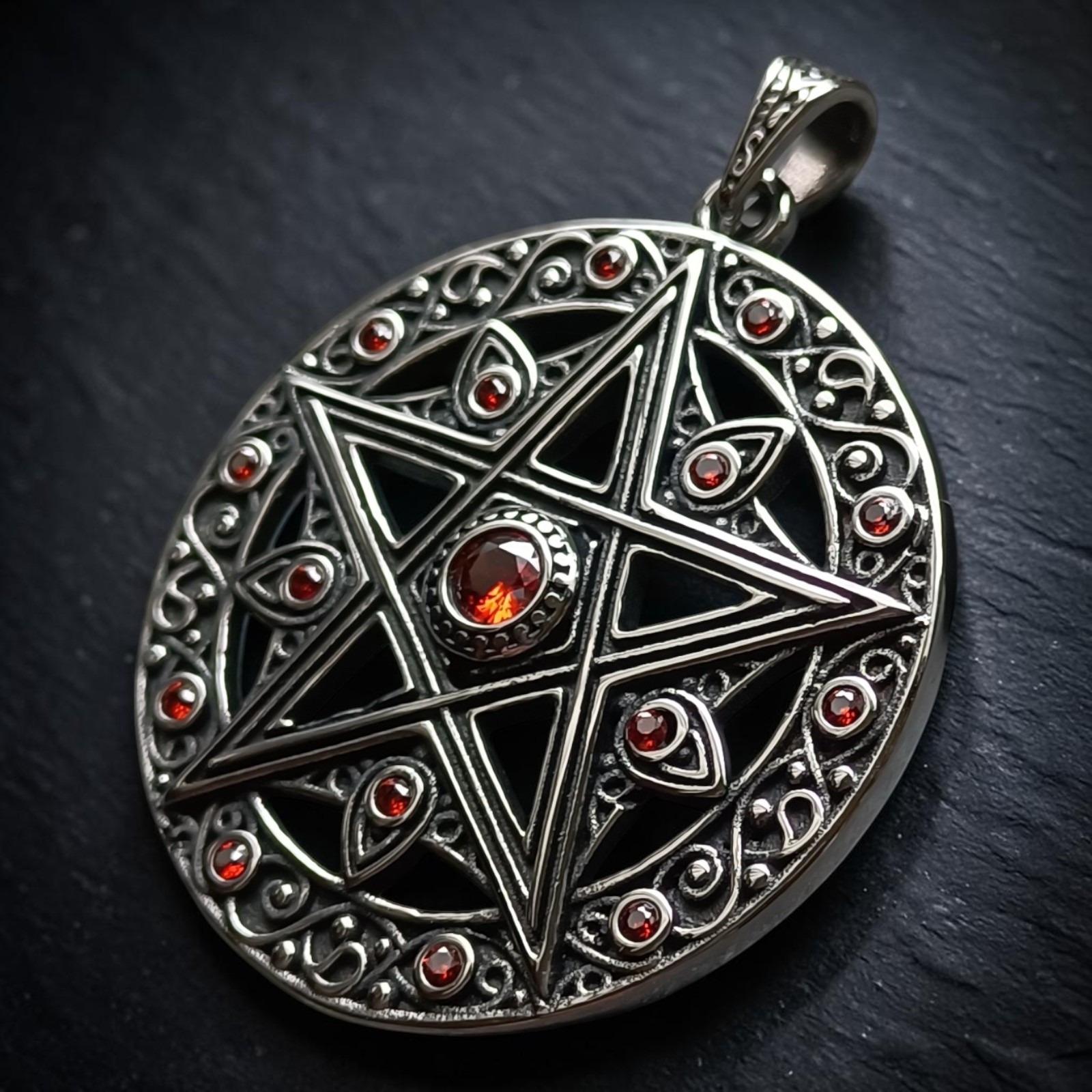 Pentagramm im Ornamentkreis mit rotem Mittelstein, seitlich auf dunklem Stein