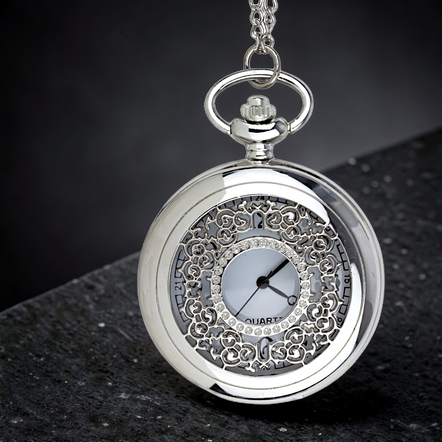 Geschlossene Taschenuhr, das Zifferblatt schimmert durch das filigrane Rankenornament