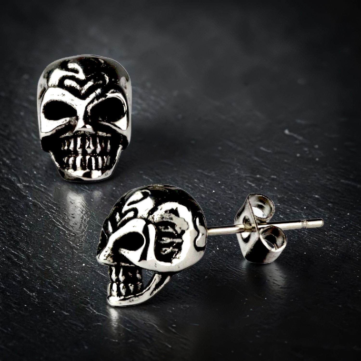 Zwei Totenkopf-Ohrstecker aus Edelstahl, plastisch gearbeitet
