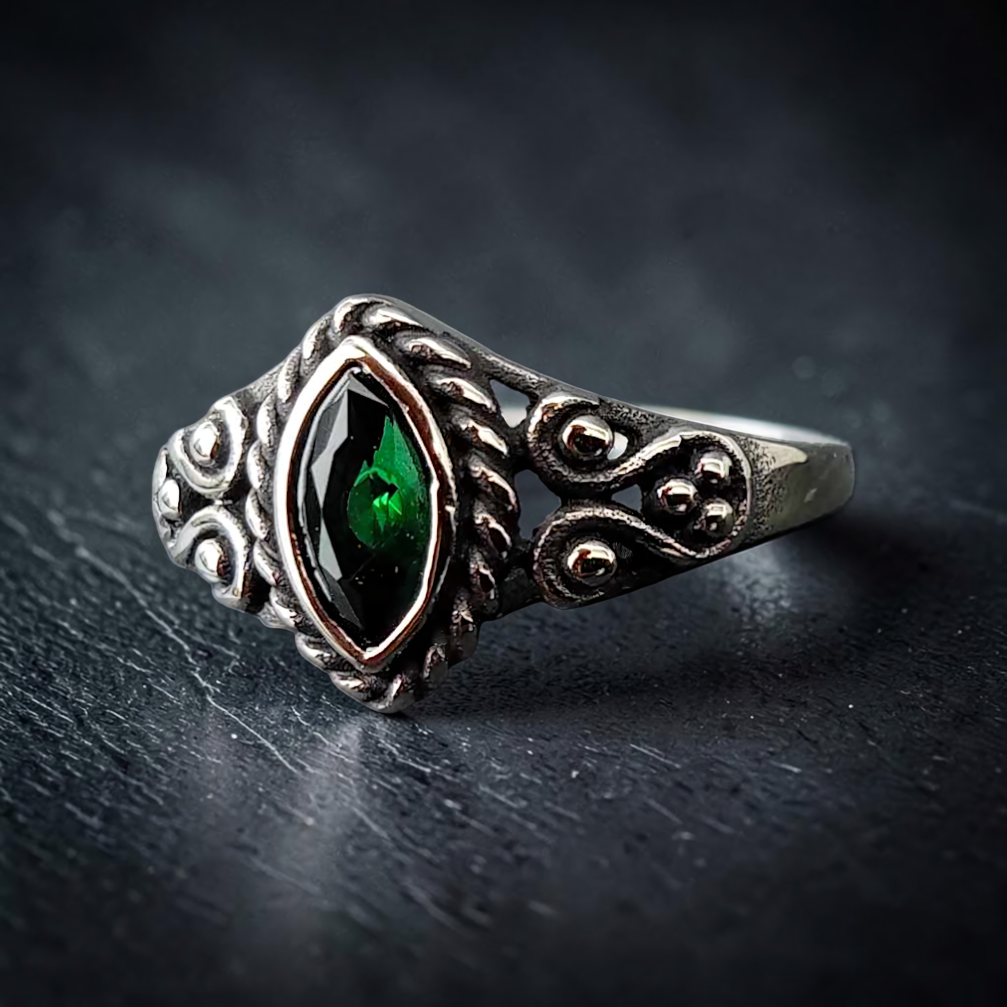 Edelstahlring Gothic Green schräg, grüner Stein und Spiralornamente im Streiflicht