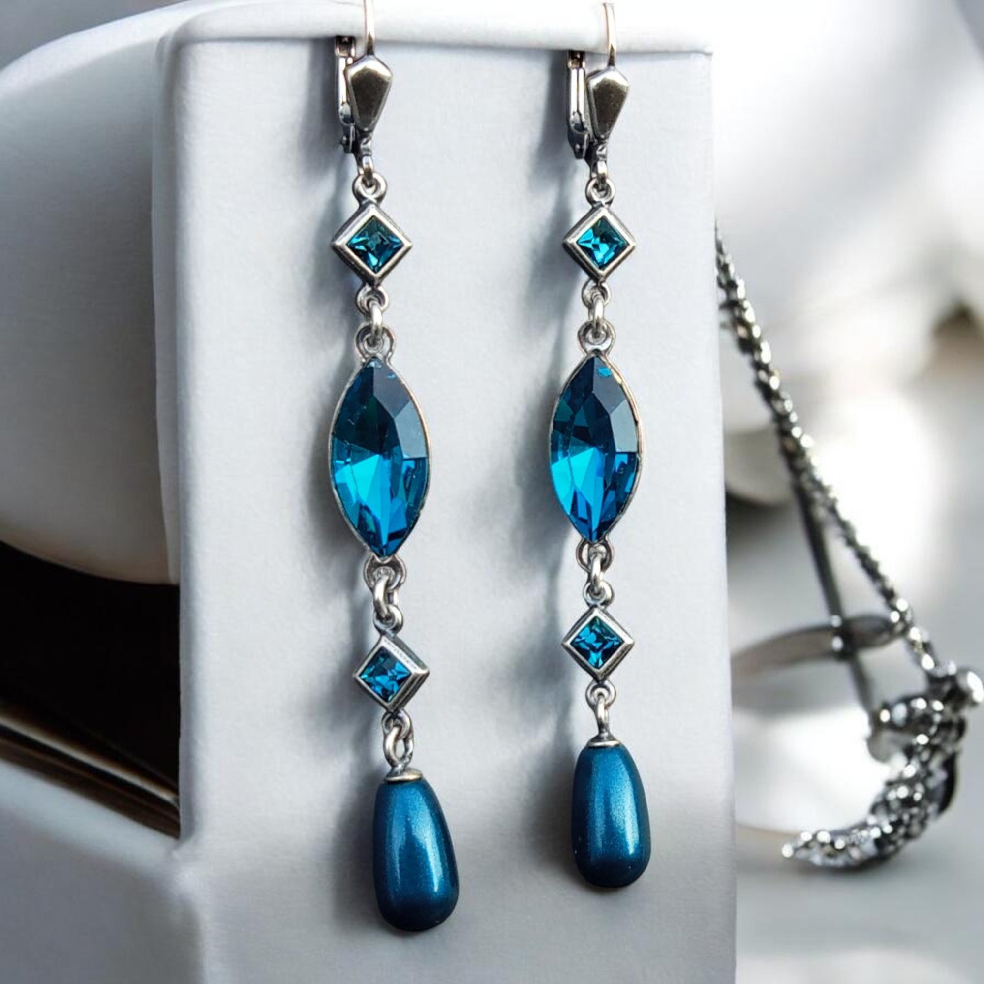 Vintage-Pearl-Ohrhänger in Petrol am Schmuckständer, die Navette leuchtet in Indicolite