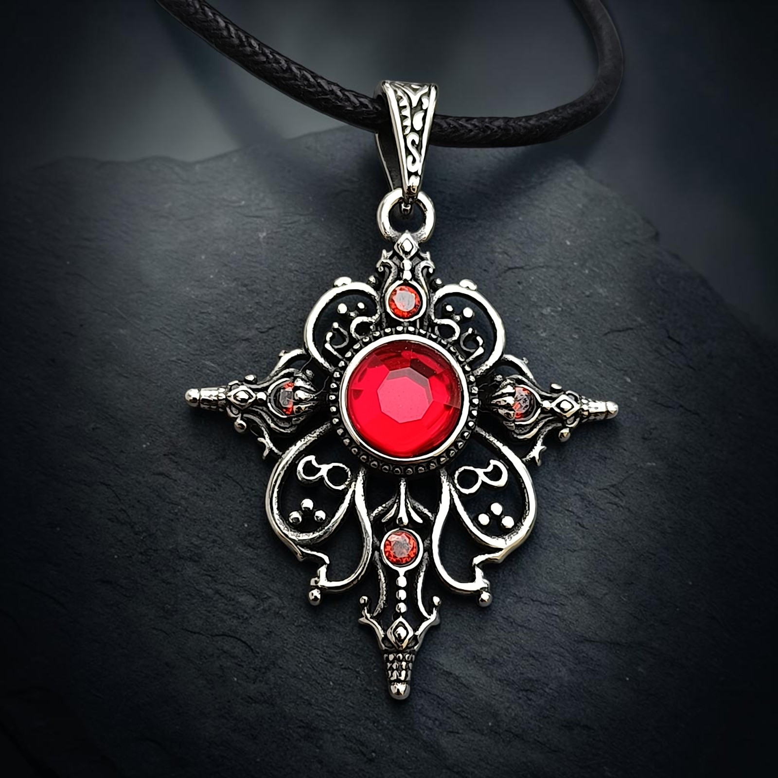Ornamentanhänger Arwen mit rotem Zirkonia vor dunklem Schiefer