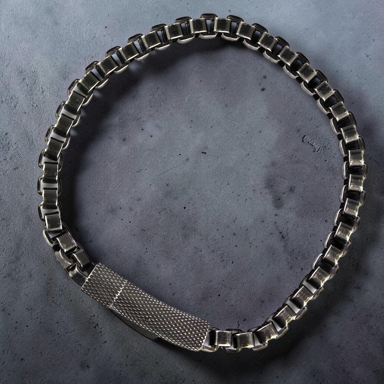 Armband aus oxidiertem Edelstahl mit quadratischen Kettengliedern auf dunklem Stein