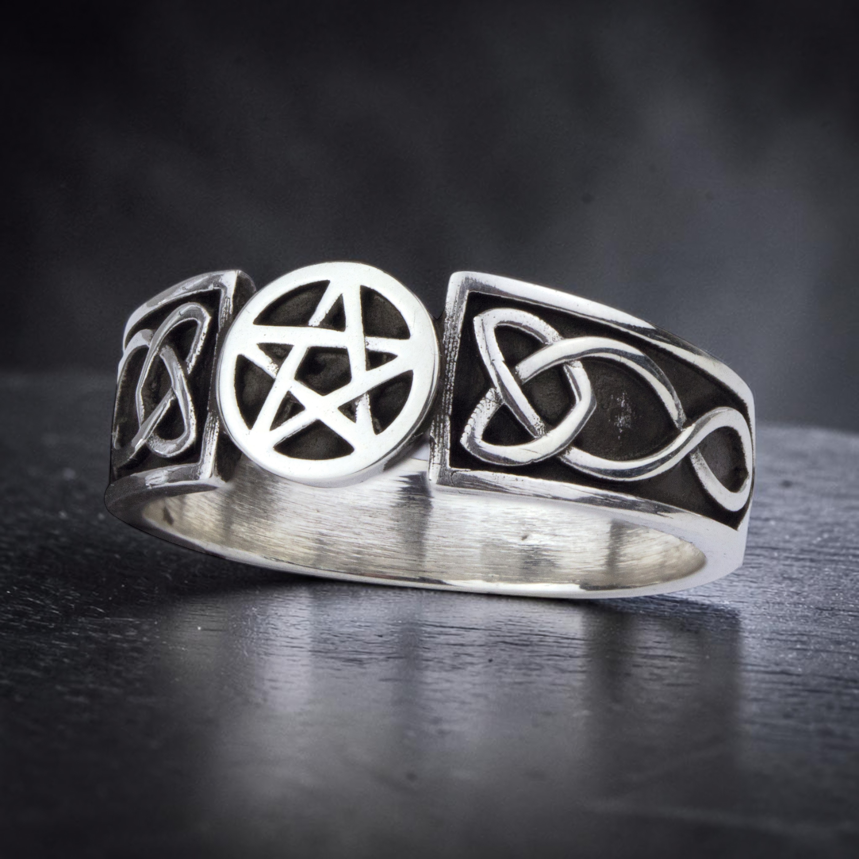 Ring Pentagramm mit keltischen Knoten aus 925 Sterling Silber, schräg von links auf dunklem Stein