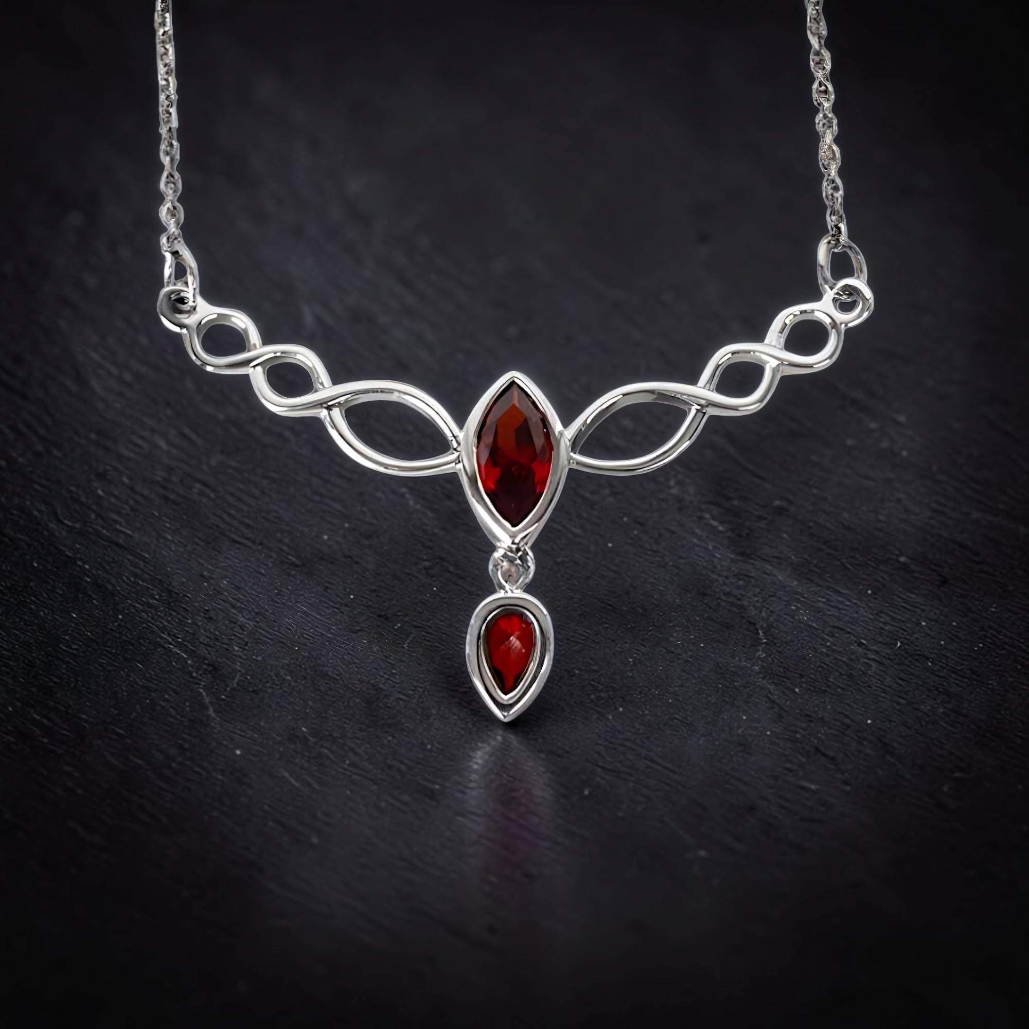 Nahaufnahme einer eleganten Halskette aus 925 Sterling Silber mit roten Zirkonia-Steinen und einem roten Tropfen am Ende, geliefert im Schmuckkarton.