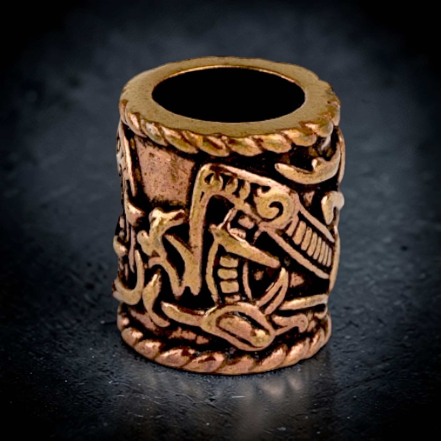 Bronzene Bartperle mit Tierornament von oben, die Bohrung läuft durch die ganze Perle
