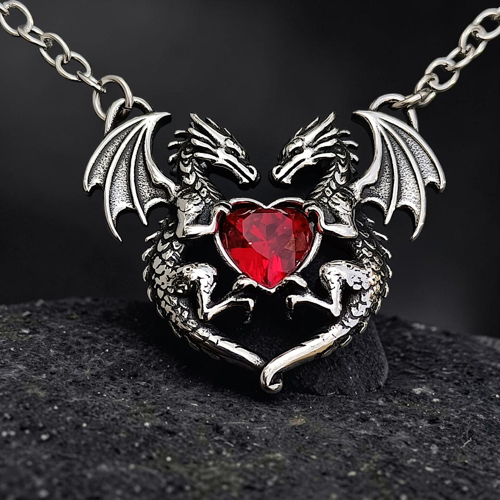 Kette Dragon Heart aus Edelstahl in Antik-Optik mit rotem Zirkonia-Herz vor Schiefer