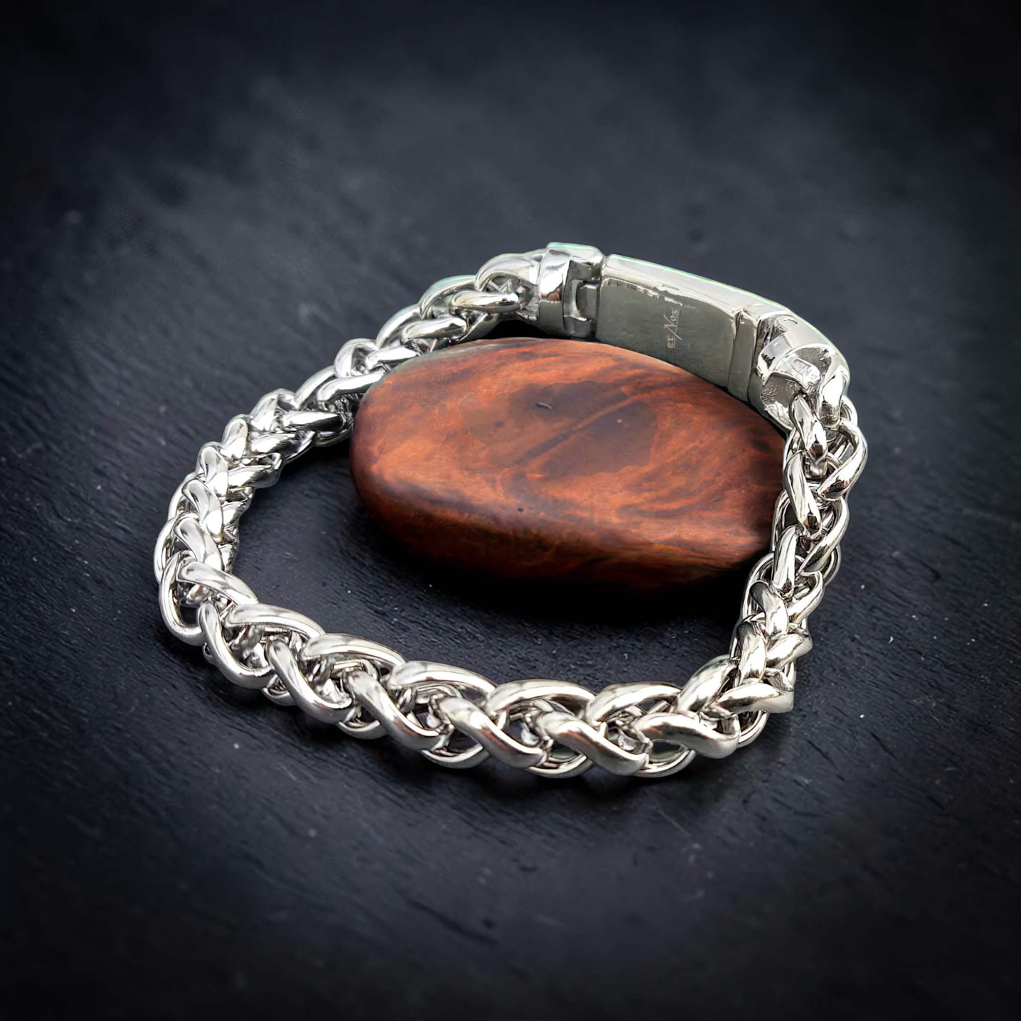 Silberfarbenes Zopfketten-Armband um einen Holzstein gelegt