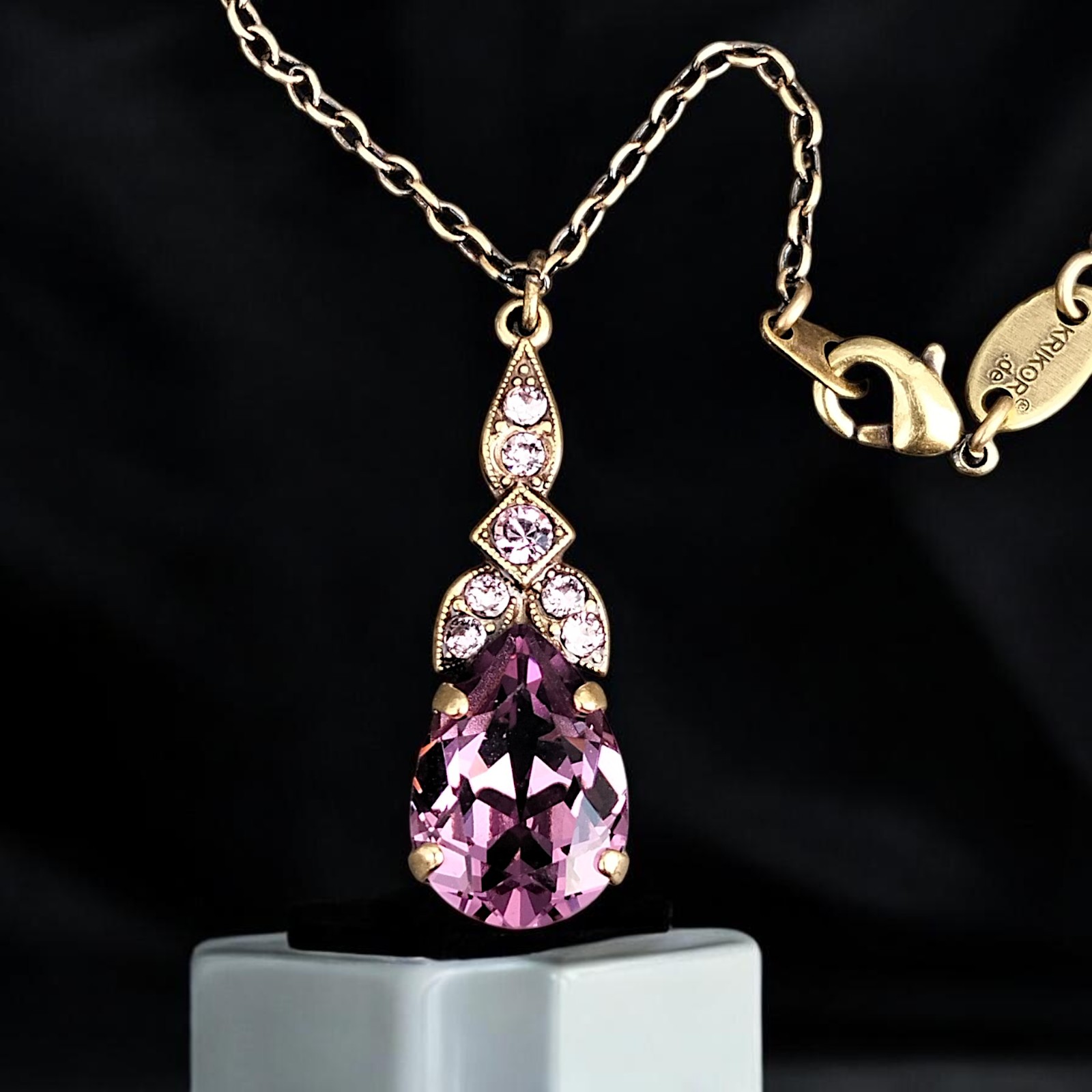 Goldfarbener Anhänger mit Iris-Tropfen an patinierter Kette