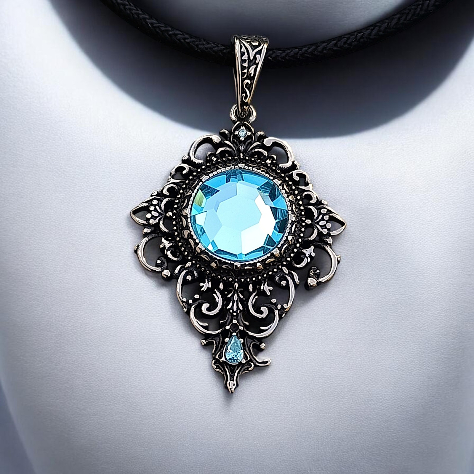 Ornamentanhänger Rhea mit hellblauem Zirkonia auf weißer Büste